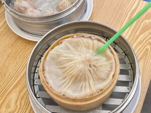Xiao Long Bao Soup Dumpling with a green straw in Shanghai, China